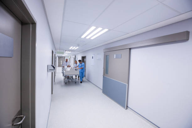 Doctor and nurse pushing emergency stretcher bed in corridor at hospital