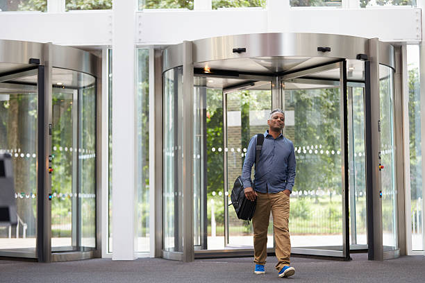 Middle aged black man entering the foyer of modern building Bogo Ivo, Installazioni, manutenzione e assistenza di porte automatiche, porte scorrevoli in provincia di Belluno. La ditta Bogo Ivo SRL lavora in tutta la provincia di Belluno e altro Trevigiano. In particolare nei comuni di Agordo, zona dell'Agordino, Alleghe, Alpago, Arsiè, Auronzo di Cadore, BELLUNO, Bellunese, Castion, Borca di Cadore,Borgo Valbelluna,Calalzo di Cadore, Canale d'Agordo, Cencenighe Agordino, Cesiomaggiore, Chies d'Alpago, Cibiana di Cadore, Colle Santa Lucia, Comelico Superiore, Cortina d'Ampezzo, Danta di Cadore, Domegge di Cadore, Falcade,Feltre, Feltrino, Fonzaso, Gosaldo, La Valle Agordina, Lamon, Limana, Livinallongo del Col di Lana, Longarone, Lorenzago di Cadore, Lozzo di Cadore, Ospitale di Cadore, Pedavena, Perarolo di Cadore, Pieve di Cadore, Ponte nelle Alpi, Rivamonte Agordino, Rocca Pietore, San Gregorio nelle Alpi, San Nicolò di Comelico, San Pietro di Cadore, San Tomaso Agordino, San Vito di Cadore, Santa Giustina, Santo Stefano di Cadore, Sedico, Selva di Cadore, Seren del Grappa, Setteville, Sospirolo, Soverzene, Sovramonte, Taibon Agordino, Tambre, Val di Zoldo, Zoldano, Vallada Agordina, Valle di Cadore, Vigo di Cadore, Vodo Cadore, Voltago Agordino, Zoppè di Cadore.